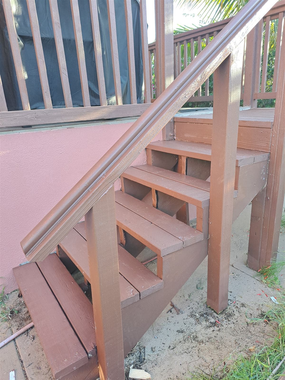 Side view of rebuilt exterior stairs with a new wood handrail