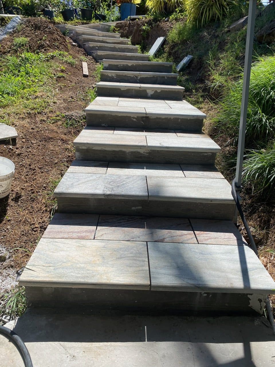 Outdoor garden steps being finished with stone tile treads