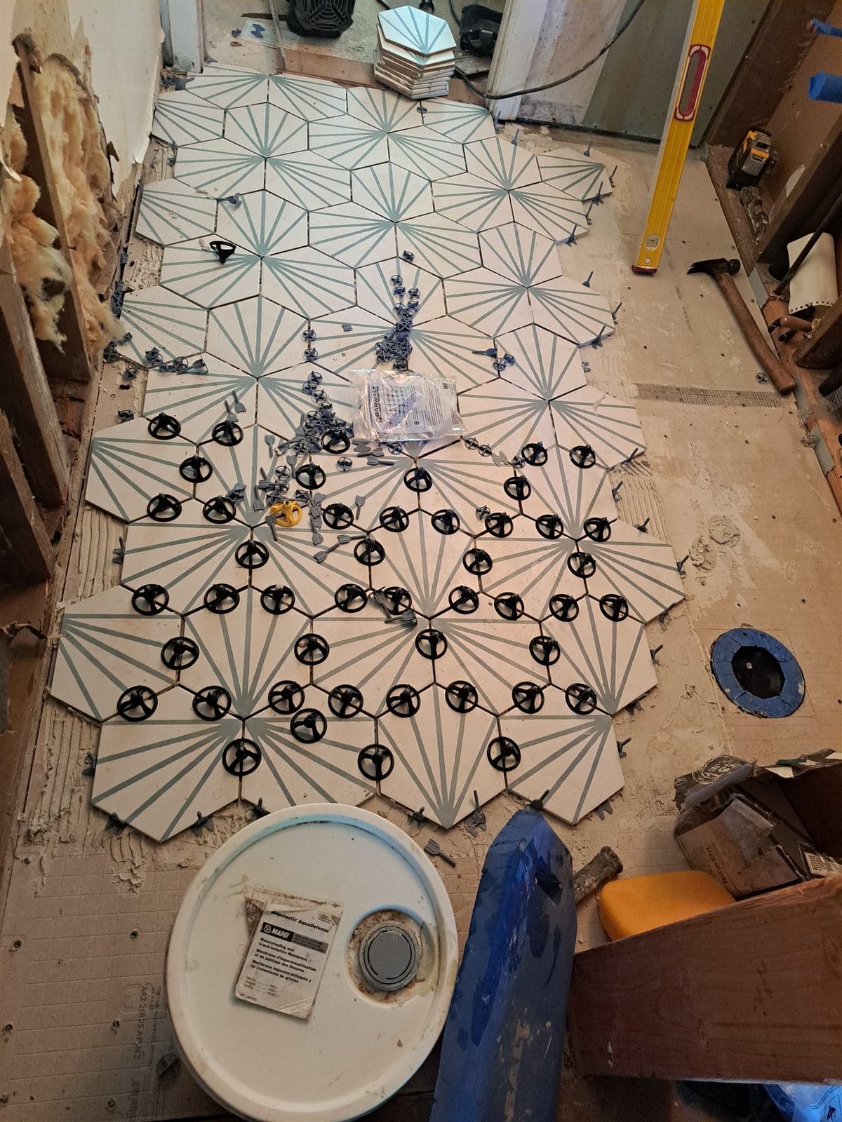 Patterned hexagon tile being laid out with leveling clips